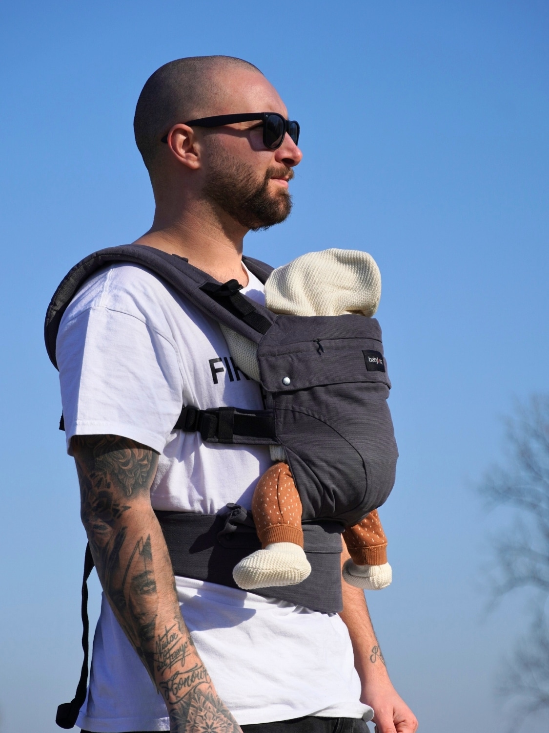 Papa portant son bébé avec le porte-bébé Babylonia Flexia anthracite en coton biologique