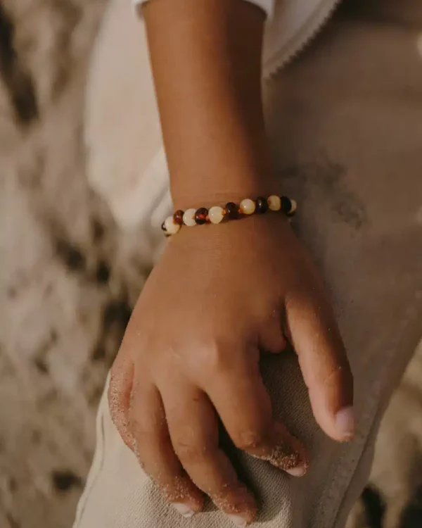 Bracelet d’ambre caramel et lait pour bébé porté au poignet
