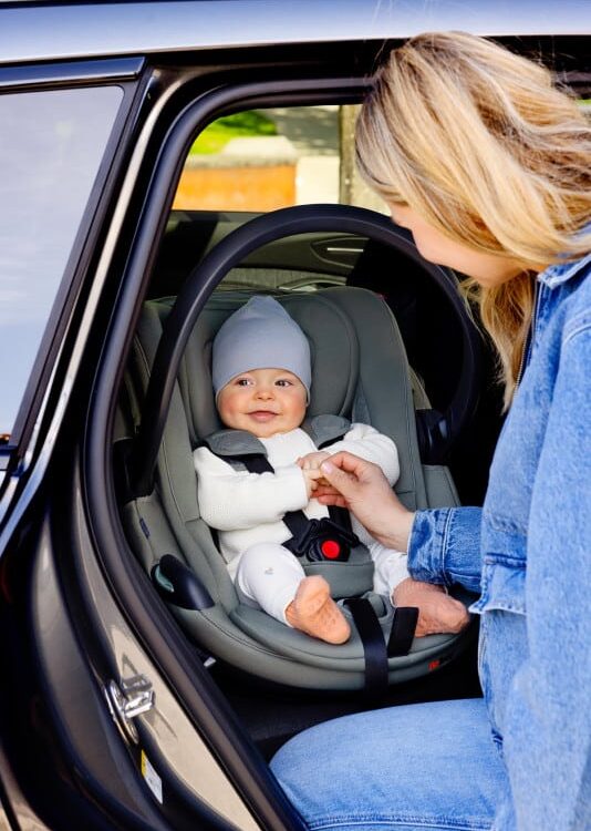 Bébé installé dans le siège auto BeSafe Go Beyond² Soft Breeze coloris Meadow Green, harnais 5 points ajusté dans une voiture