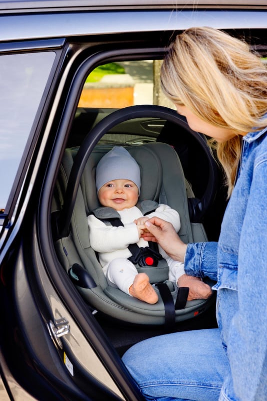 Bébé installé dans le siège auto BeSafe Go Beyond² Soft Breeze coloris Meadow Green, harnais 5 points ajusté dans une voiture
