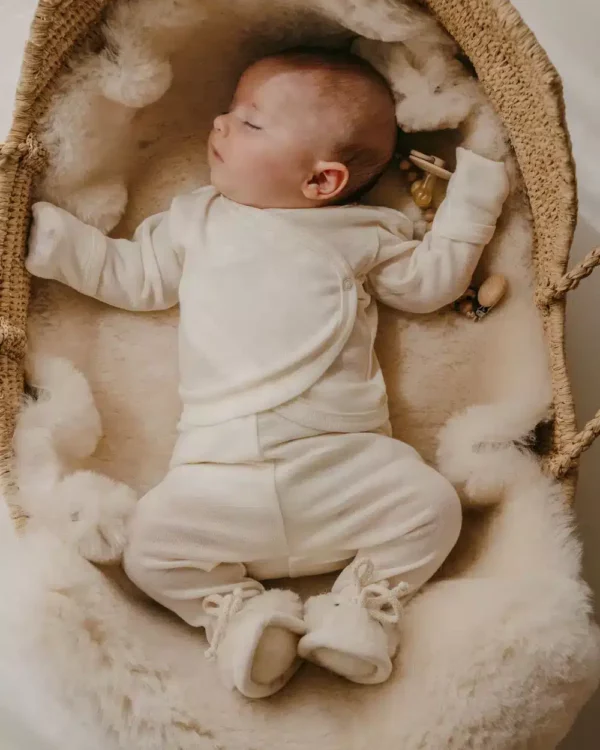 Bébé qui dort dans un couffin sur une peau de mouton naturelle Miijo