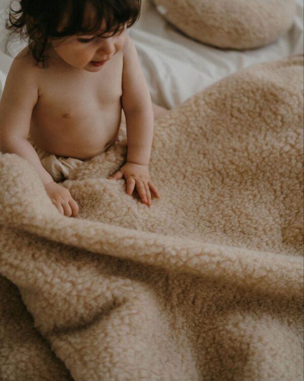 Bébé enveloppé dans une couverture en laine naturelle Miijo couleur crème