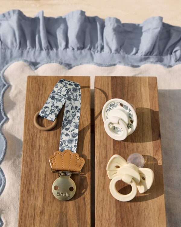 Pack Elodie “Garden” : attache-sucette et deux sucettes assorties posées sur planches en bois, lumière naturelle.