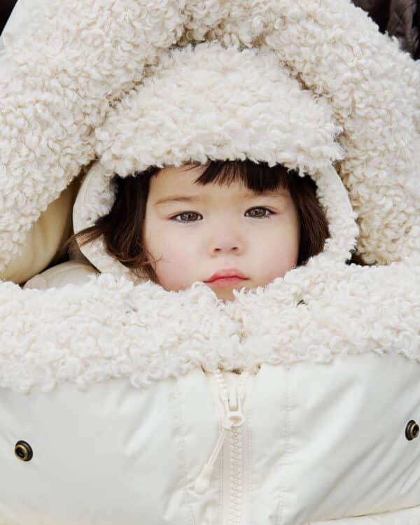 Bébé blotti dans la chancelière Elodie Details Soft Sherpa avec capuche en sherpa écru
