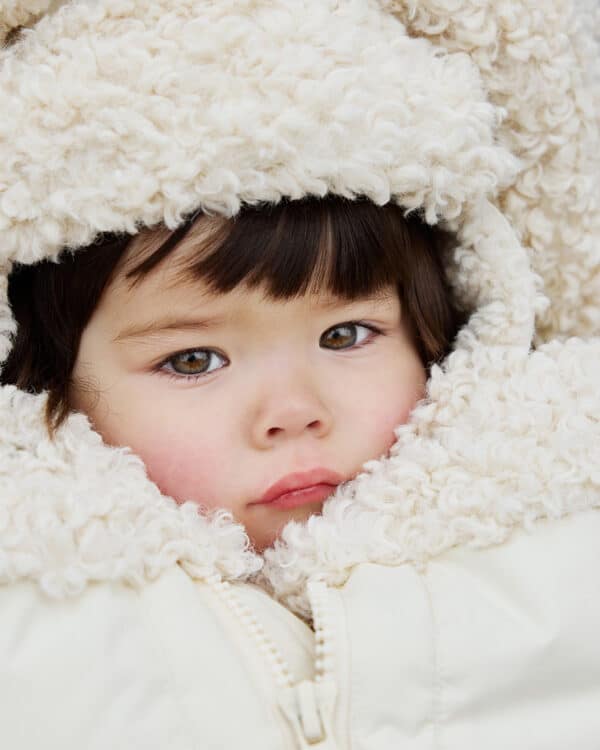 Zoom sur la capuche en sherpa écru de la chancelière Soft Sherpa Elodie Details avec bébé installé