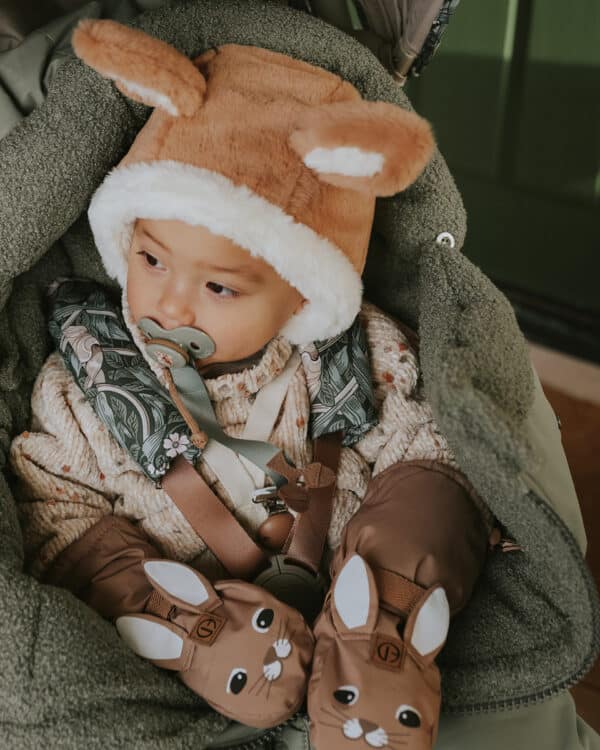 Bébé en poussette dans la neige avec chancelière Hazy Jade