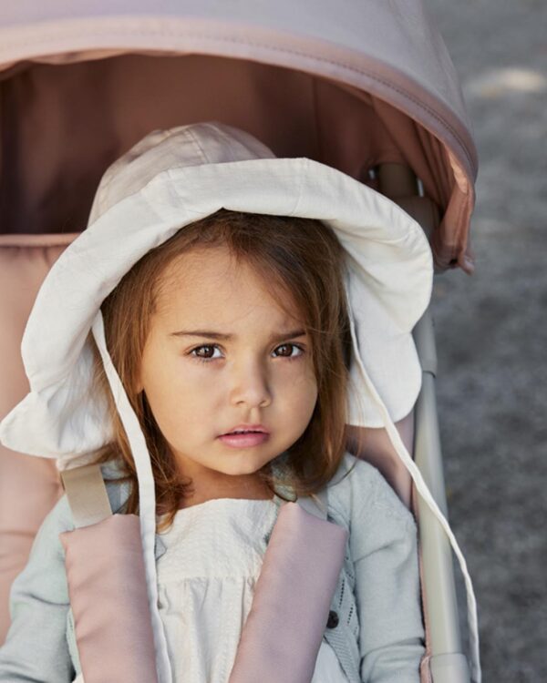 Enfant regardant la caméra dans la poussette compacte Elodie MONDO Blushing Pink