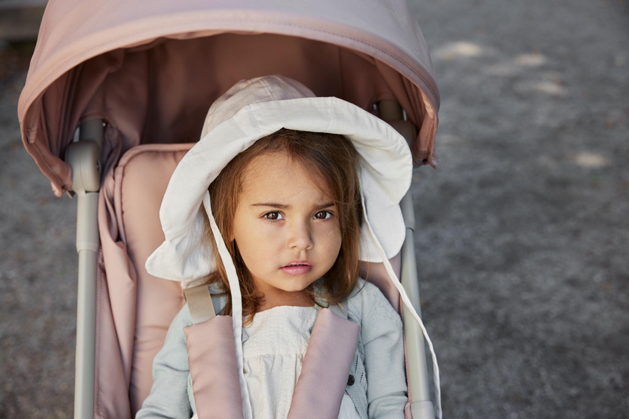 Enfant regardant la caméra dans la poussette compacte Elodie MONDO Blushing Pink