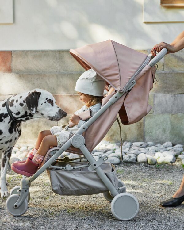 Enfant dans la poussette Elodie MONDO Blushing Pink saluant un chien dalmatien pendant une promenade