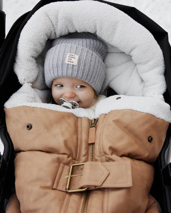 Bébé dans une poussette avec chancelière Elodie Details Aviator Brown, protection coupe-vent