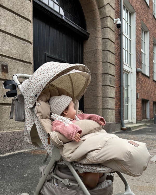 Bébé dans une poussette avec chancelière Elodie Pure Khaki, utilisation en extérieur en ville