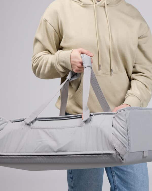 Photo studio du Voksi Carry Me gris & crème, couffin souple porté par les anses.