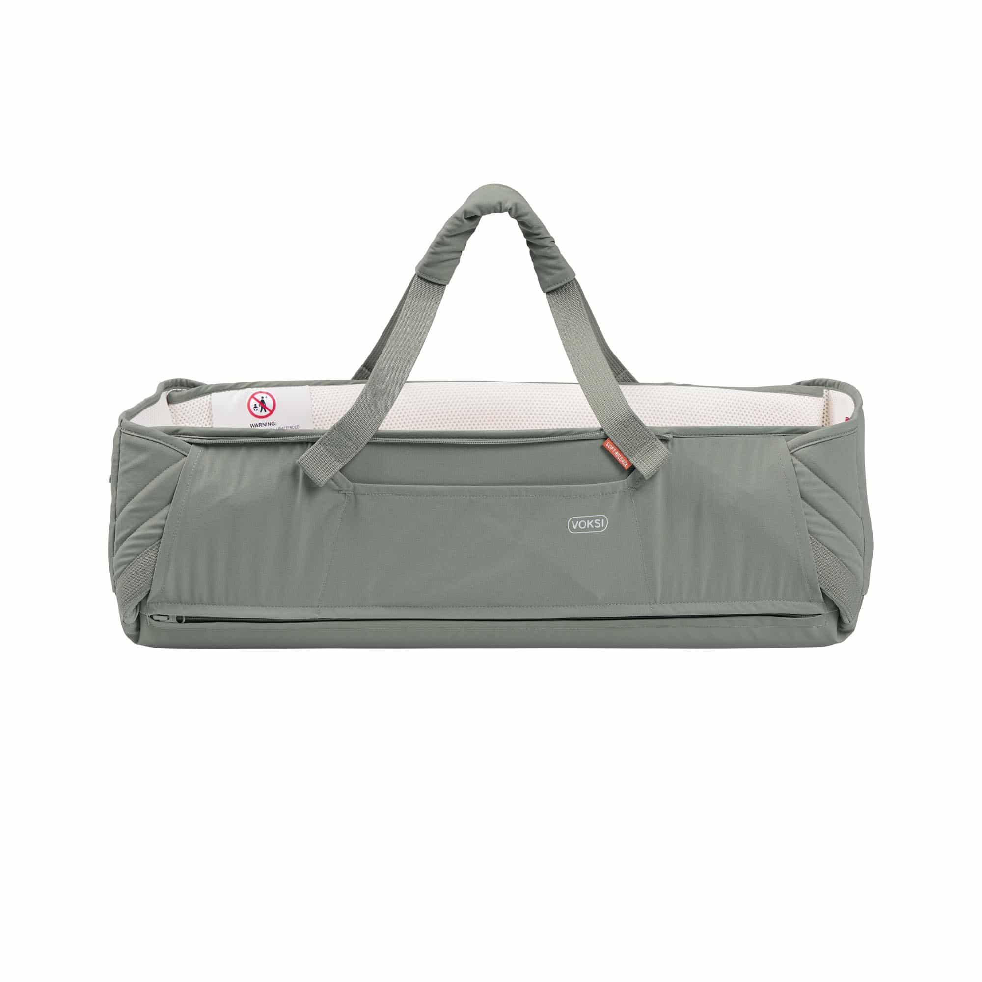Voksi Carry Me vert meadow et crème, couffin bébé nomade avec poignées de transport, design nordique.