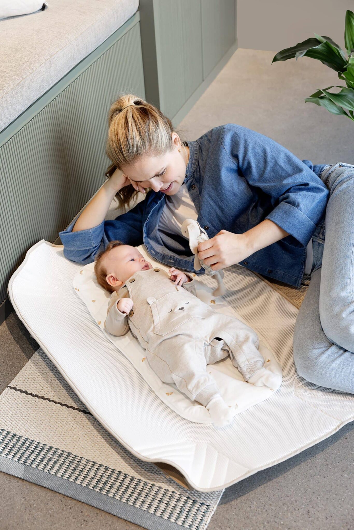 Parent joue avec bébé sur un matelas Voksi Carry Me, surface d’appoint confortable pour l’éveil à la maison.