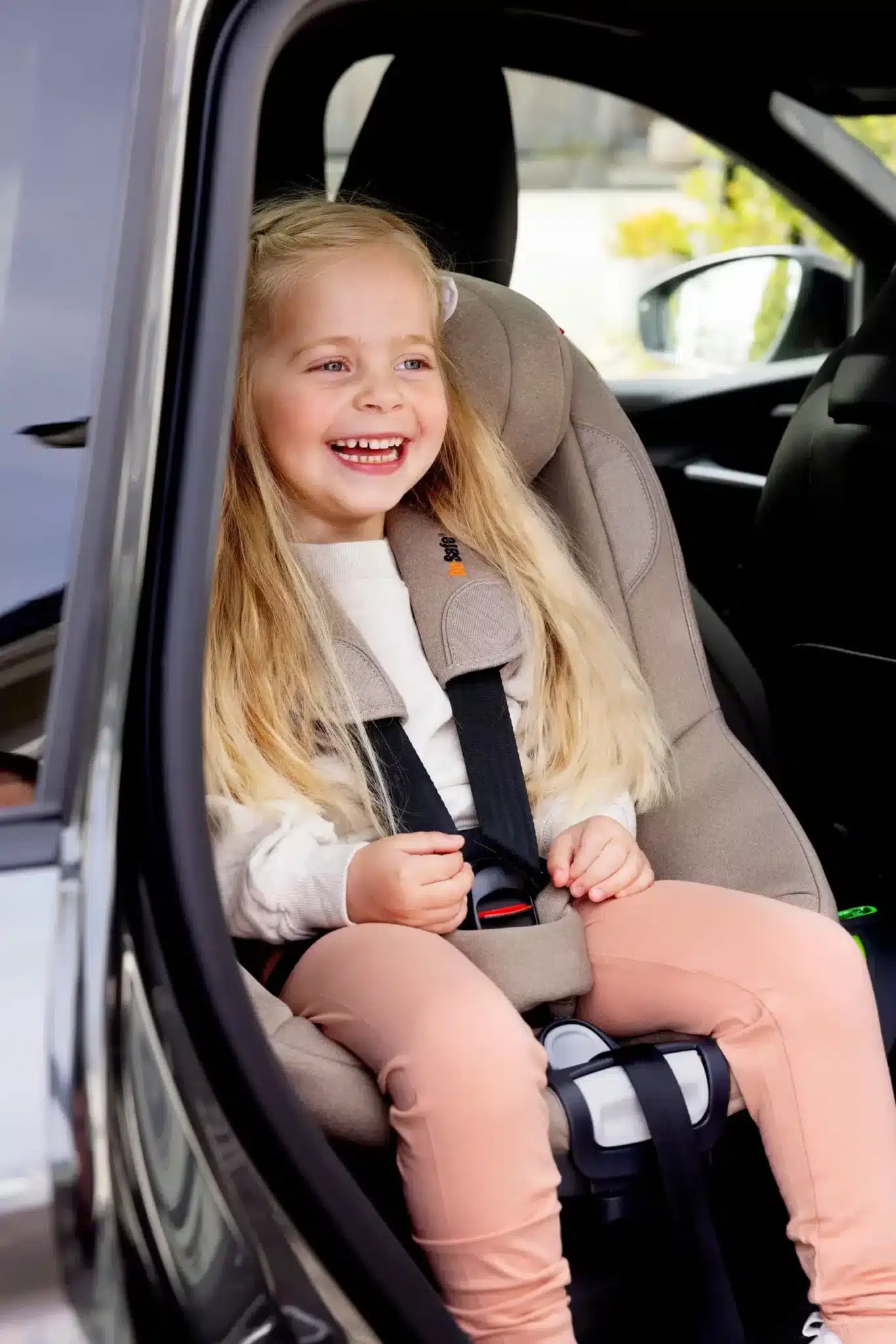 Enfant souriante attachée dans le siège auto BeSafe Beyond² 360 dark sand