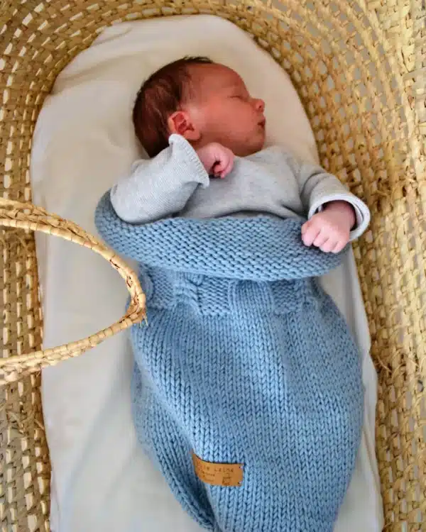 Nouveau-né endormi dans un cocon de naissance en laine mérinos bleu layette Ma Petite Laine