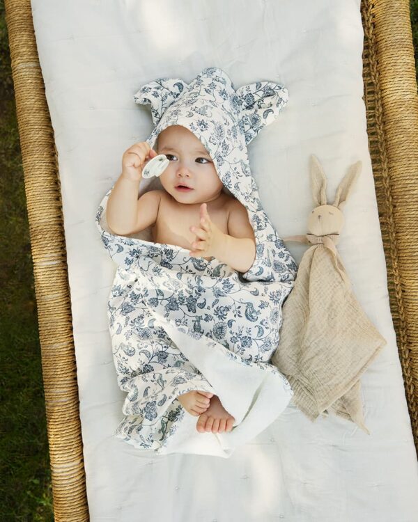 Bébé enveloppé dans la cape de bain à capuche Elodie Garden Leo Toile avec doudou assorti