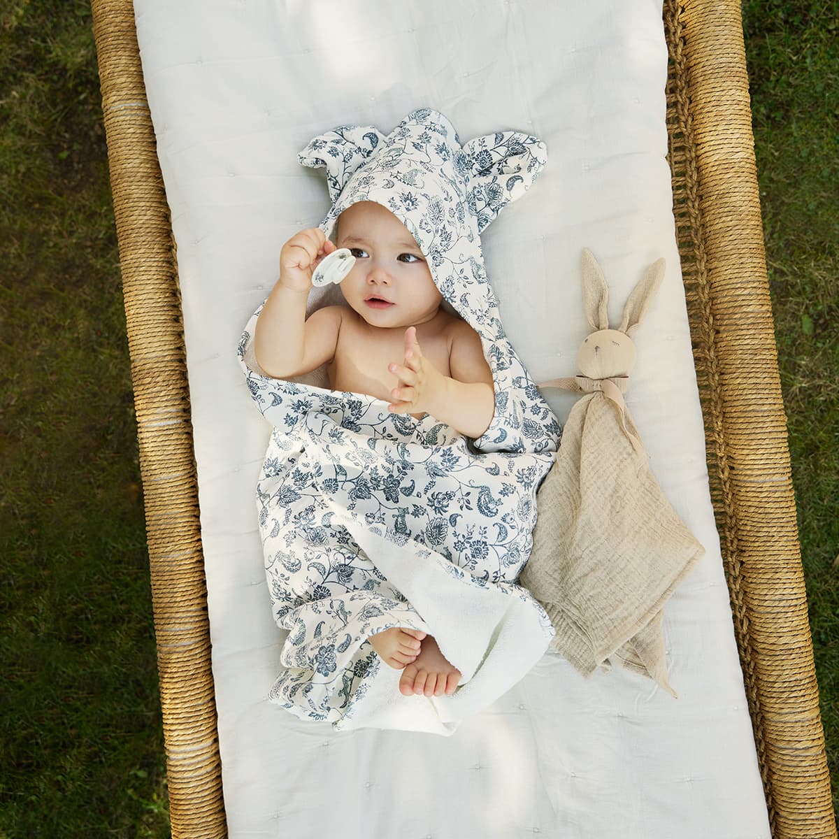 Bébé enveloppé dans la cape de bain à capuche Elodie Garden Leo Toile avec doudou assorti