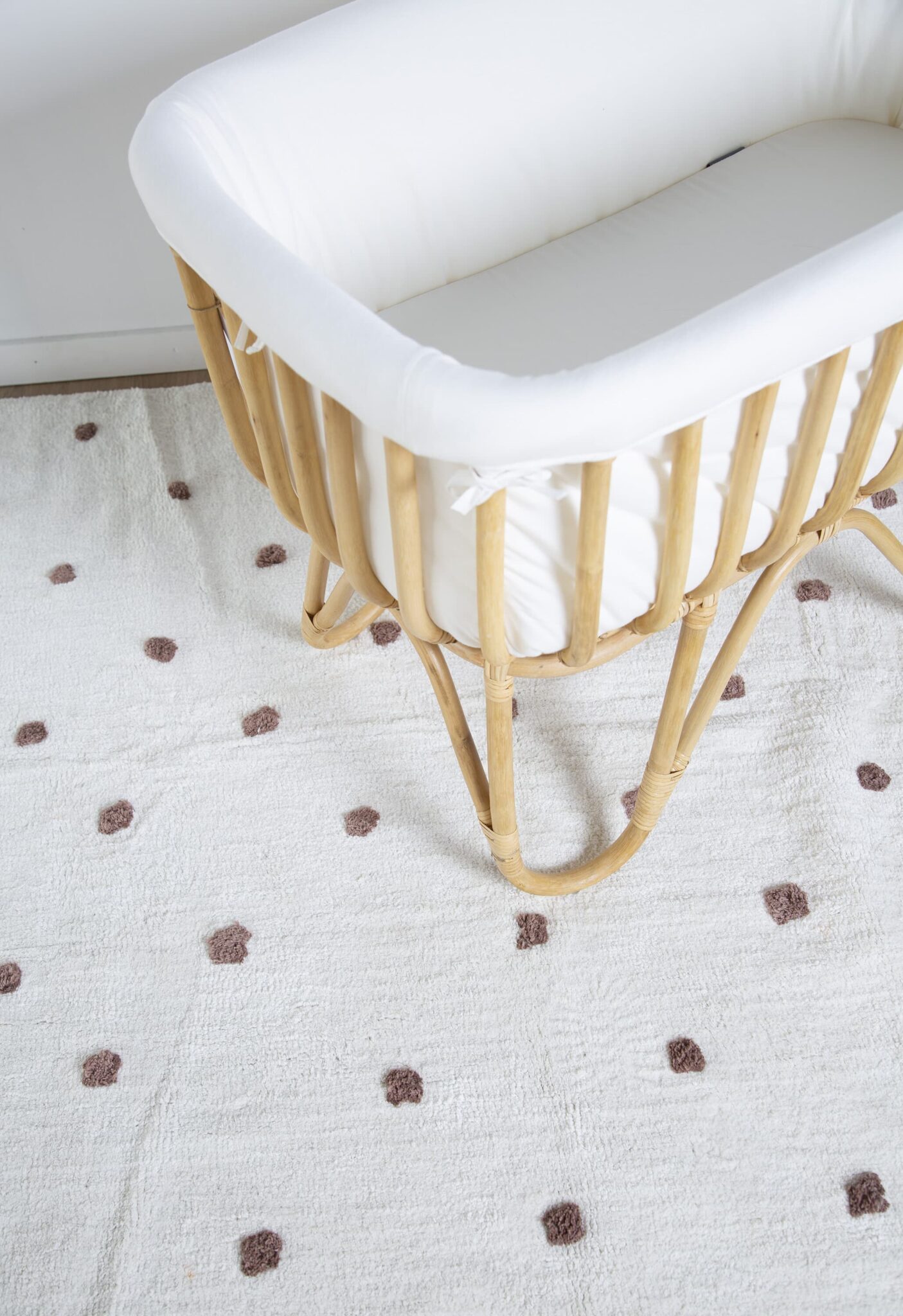 Vue plongeante du berceau en rotin Childhome avec matelas blanc