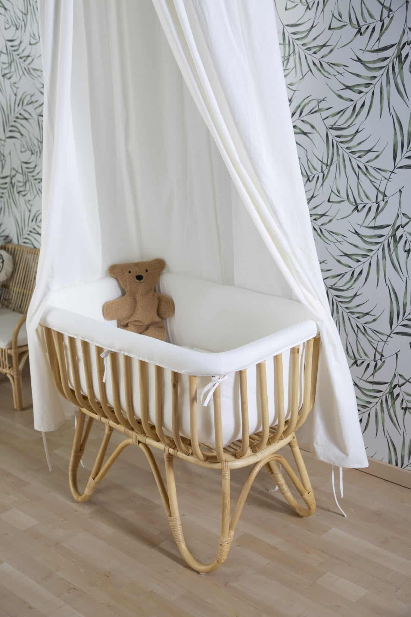 Berceau en rotin Childhome avec ciel de lit blanc dans une chambre bébé