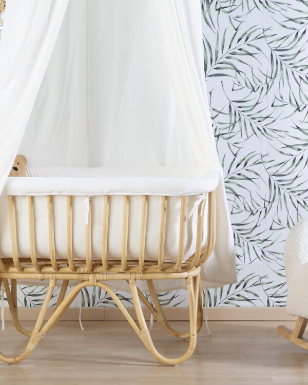 Berceau en rotin Childhome avec ciel de lit dans une chambre bébé décorée