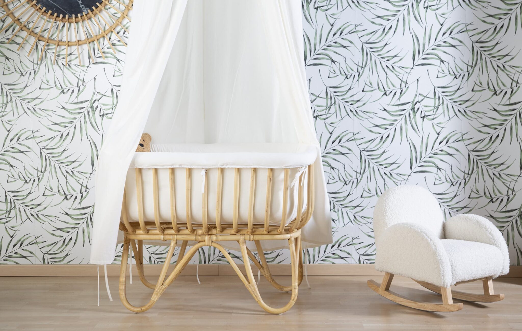Berceau en rotin Childhome avec ciel de lit dans une chambre bébé décorée