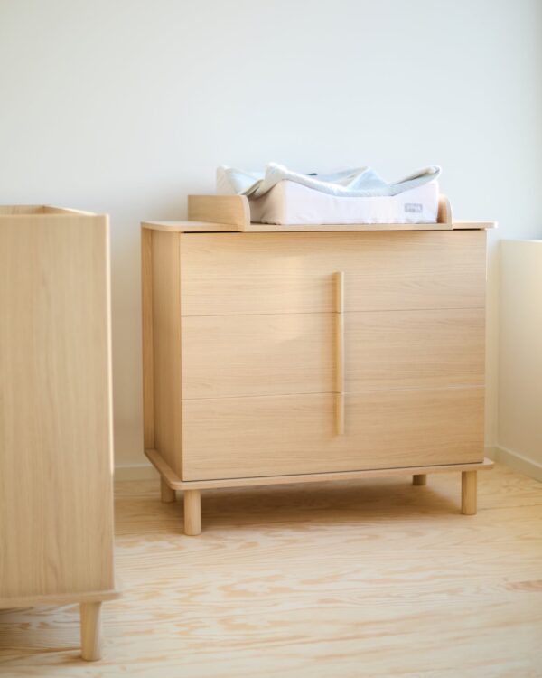 Commode bébé Childhome Nordica Natural avec plan à langer dans une chambre bébé lumineuse