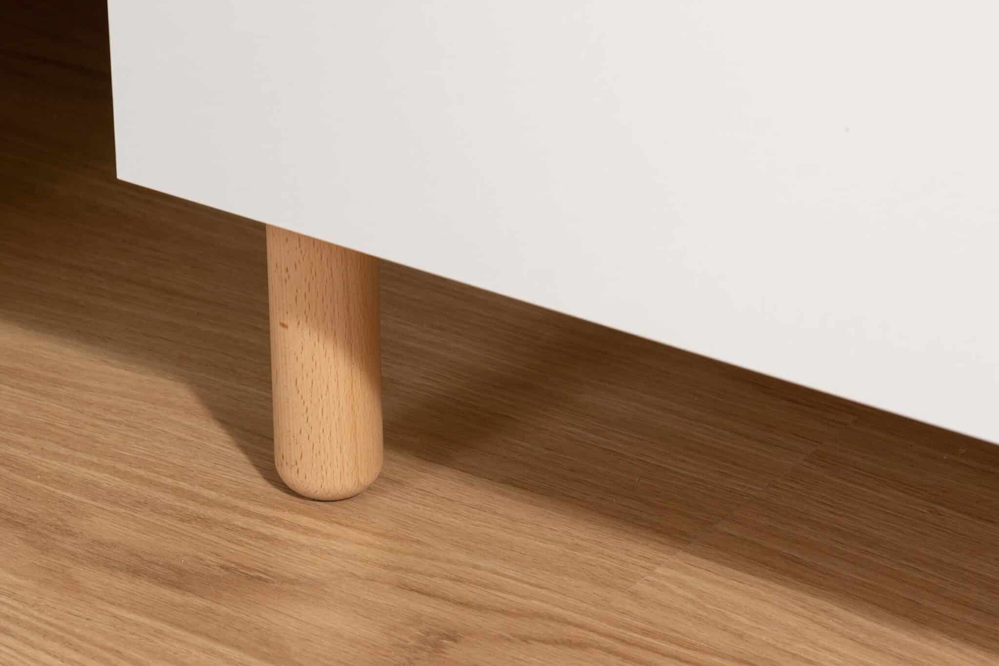 Détail du pied en bois clair de la commode bébé Childhome Wonder White