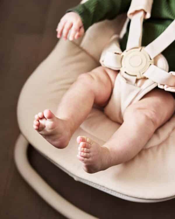 Bébé installé dans le transat GRACE Elodie Powder Pink avec harnais 5 points